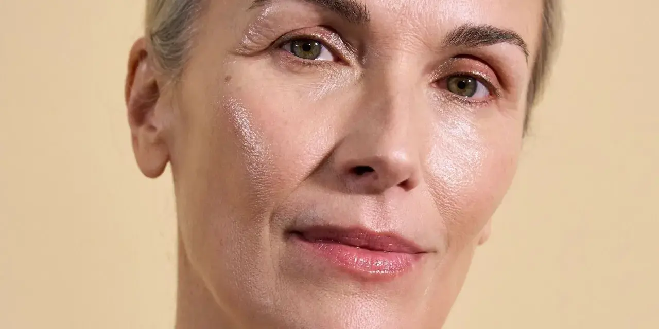 Visage d'une femme aux cheveux gris, peau lumineuse et hydratée, suggérant l'efficacité des peptides pour une peau éclatante.