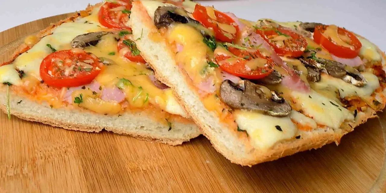 Dwie pyszne pizze na bagietce z pomidorami, pieczarkami i serem. Idealne na szybki obiad.