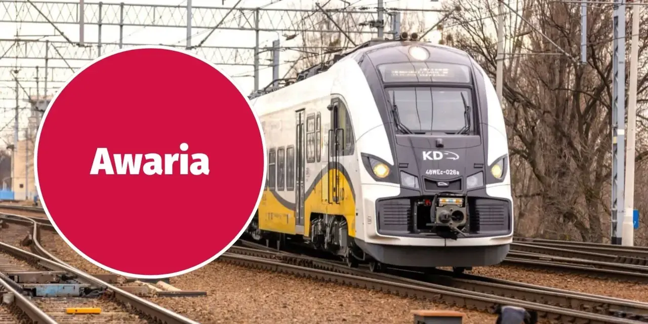 Pociąg KD stoi na torach, a czerwone koło z napisem "Awaria" sugeruje problem z zasilaniem, być może zerwana sieć trakcyjna.