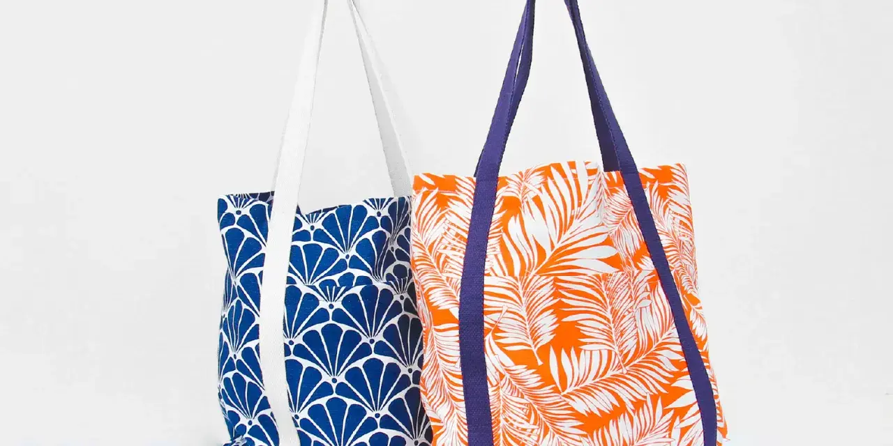 Deux sacs fourre-tout aux motifs vibrants : un bleu avec des éventails blancs, l'autre orange avec des feuilles de palmier blanches. Un patron de sac gratuit à télécharger pour créer vos propres accessoires.
