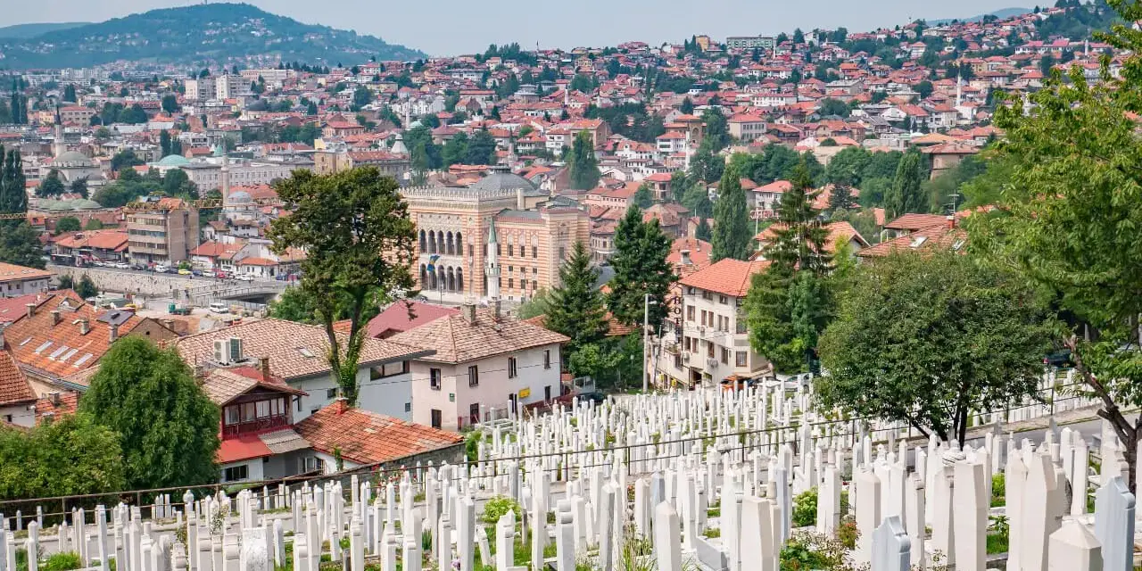 Widok na cmentarz i miasto, gdzie zobaczyć można zabytkowe budynki i wzgórza. Sarajewo co zobaczyć.