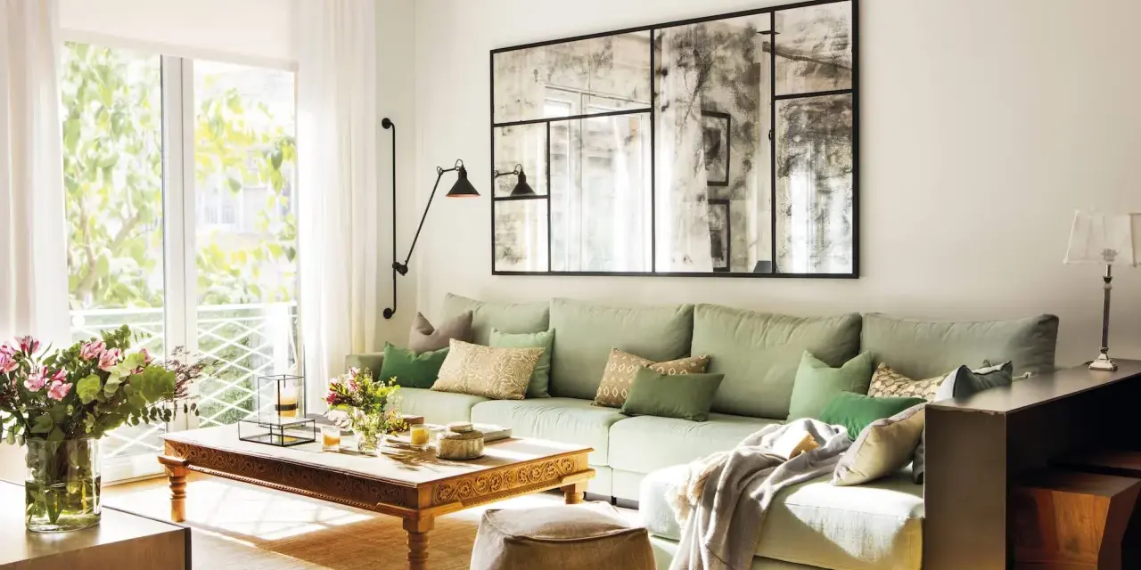 Un espejo grande y decorativo es una excelente idea de qué poner detrás del sofá, aportando amplitud y estilo a la sala.