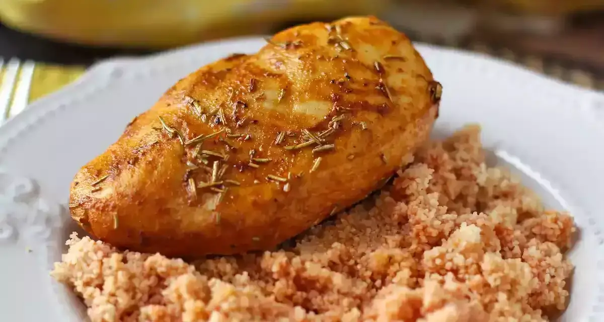 Deliziosi fusi di pollo in friggitrice ad aria, dorati e profumati al rosmarino, serviti su un letto di couscous.