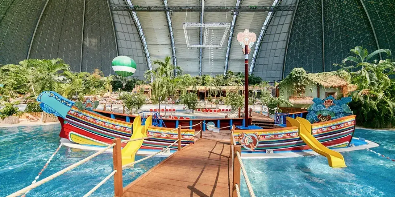 Kolorowy statek z żółtymi zjeżdżalniami w tropikalnym basenie. Idealne miejsce na wakacje, sprawdź bilety na tropical islands!