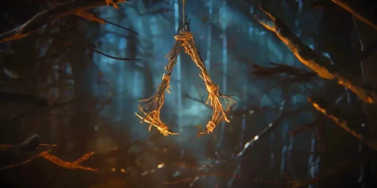 W lesie wisi symbol przypominający literę "A", wykonany z gałązek i sznurka. To znak z gry Assassin's Creed Hexe.