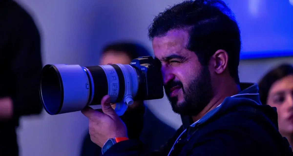Un fotografo con una Canon EOS scatta foto, pensando a quanto guadagna un fotografo.