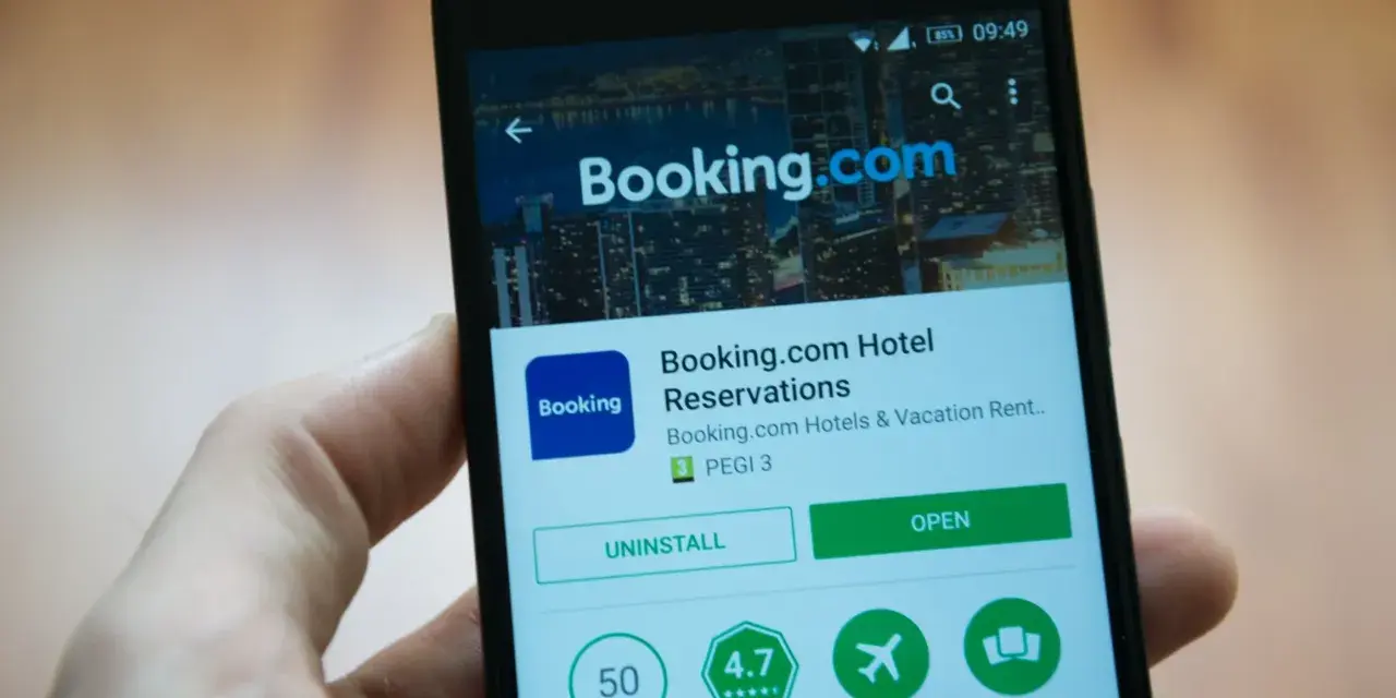Telefon z aplikacją Booking.com. Użytkownik przegląda szczegóły, być może w celu zgłoszenia booking reklamacja.