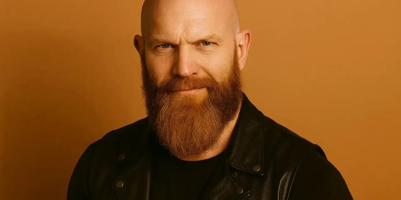 Hombre calvo con barba vikinga, mirada intensa y chaqueta de cuero.