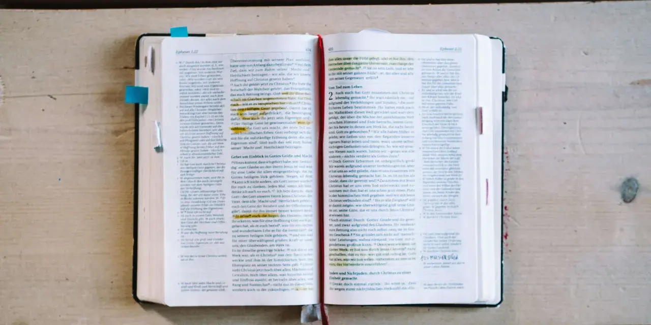 Ein aufgeschlagenes Buch mit Bibeltexten, das die Frage "was bedeutet evangelisch" beleuchtet.