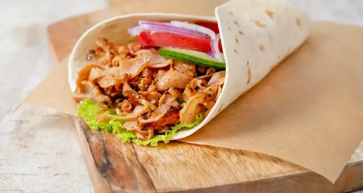 Pyszny kebab w picie z soczystym mięsem, świeżymi warzywami i chrupiącą sałatą, gotowy do zjedzenia.