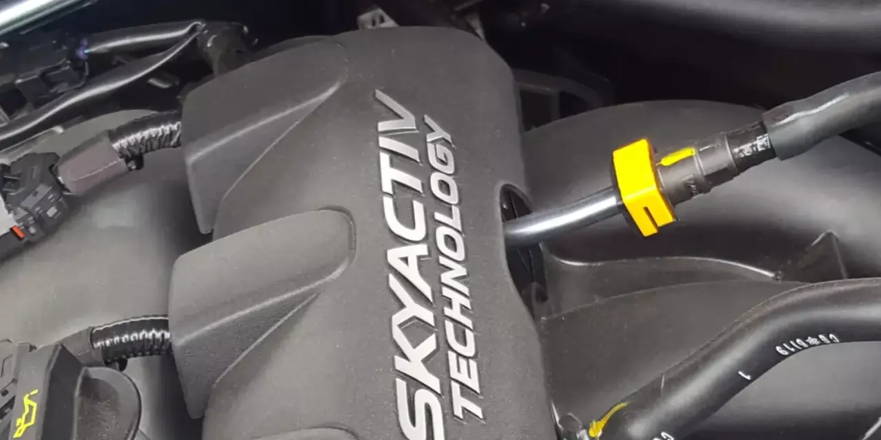 Silnik SKYACTIV TECHNOLOGY, prawdopodobnie najlepszy silnik benzynowy, z widocznymi przewodami i złączkami.