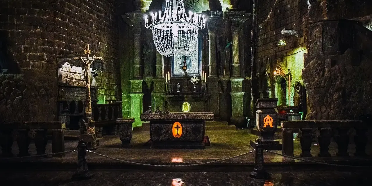 Wnętrze kaplicy w kopalni soli w Wieliczce, jednej z najpiękniejszych kopalnie do zwiedzania w Polsce. Kryształowy żyrandol, ołtarz i rzeźby z soli.