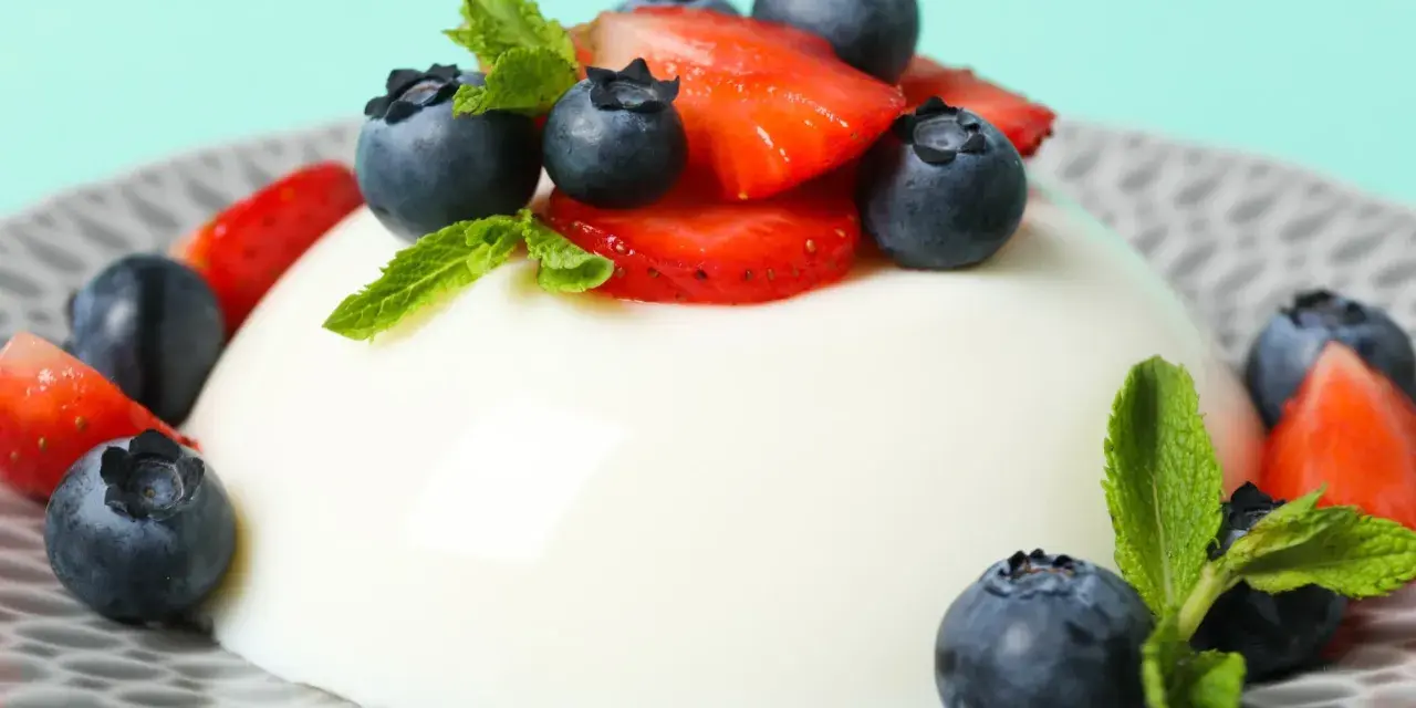 Szybkie ciasto z 4 składników: panna cotta z jagodami i truskawkami, ozdobiona miętą.