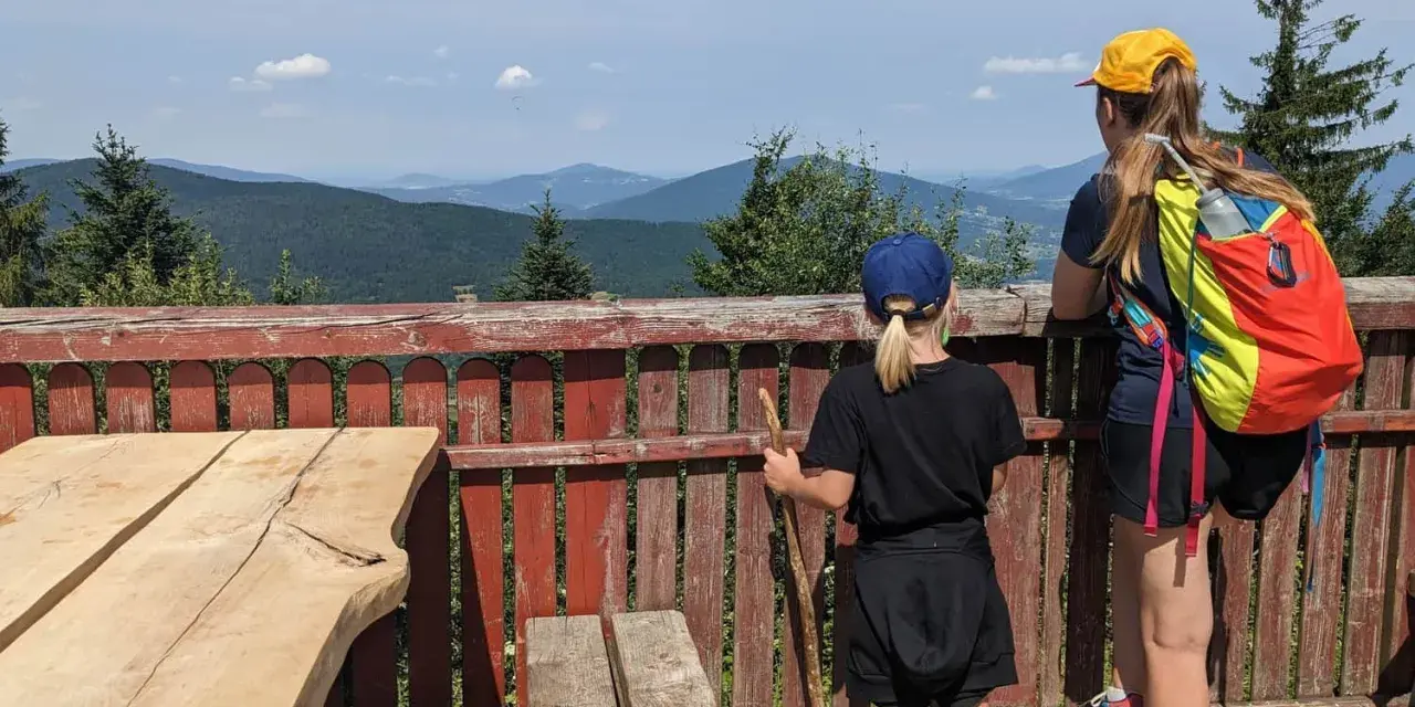 Dwie dziewczynki podziwiają malownicze widoki z tarasu. To idealne miejsce na odkrywanie widokowych szlaków blisko Krakowa.