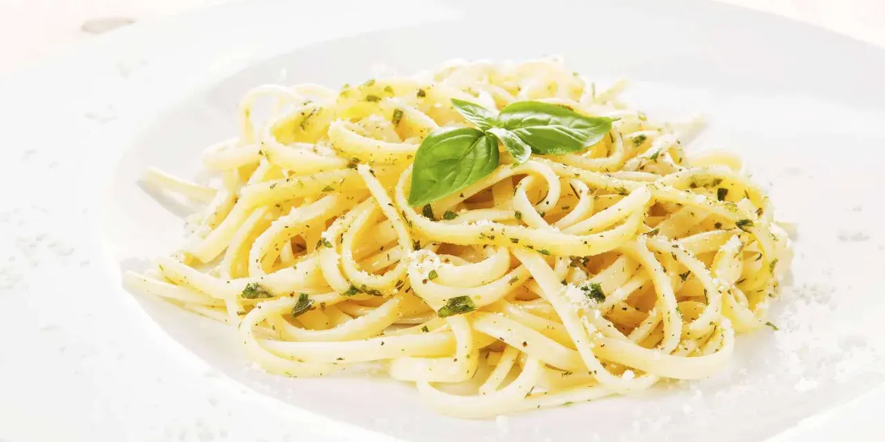 Ein Teller Spaghetti mit Kräutern und Parmesan, garniert mit Basilikum. Perfekt für einfache Spaghetti Rezepte.