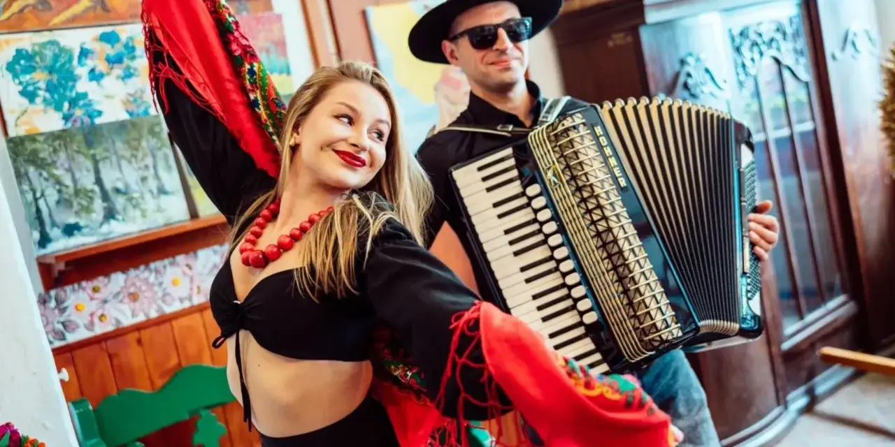 Zespół góralski disco polo w akcji! Wokalistka w barwnym stroju i akordeonista tworzą radosną atmosferę.
