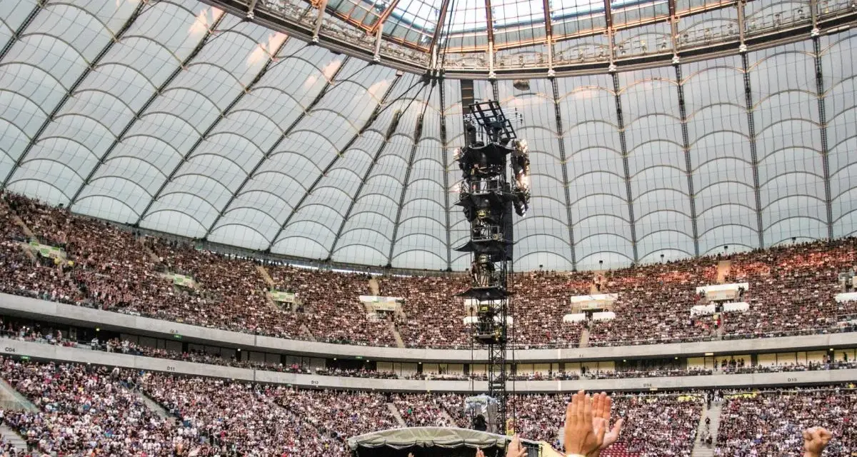 Roztanczony PGE Narodowy w Warszawie, tłumy ludzi na koncercie pod dachem stadionu.
