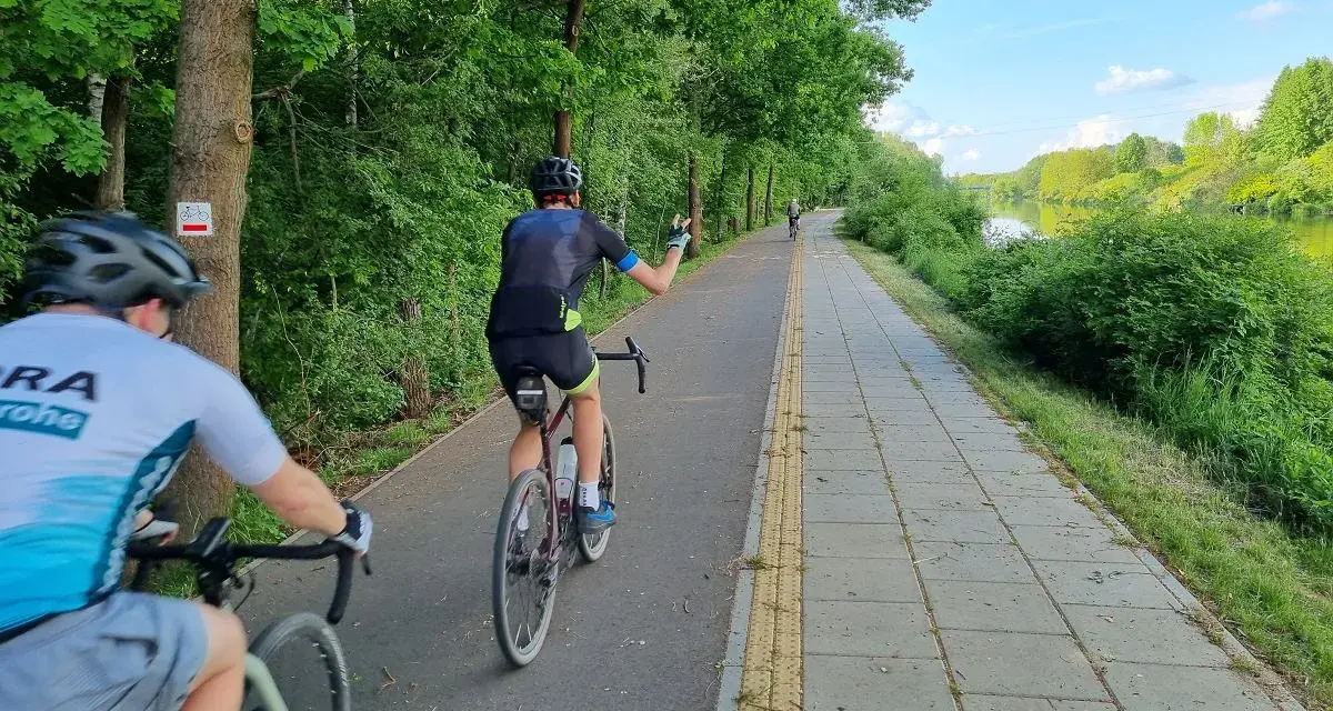 Rowerzyści na malowniczych trasach rowerowych w Warszawie, wzdłuż rzeki.