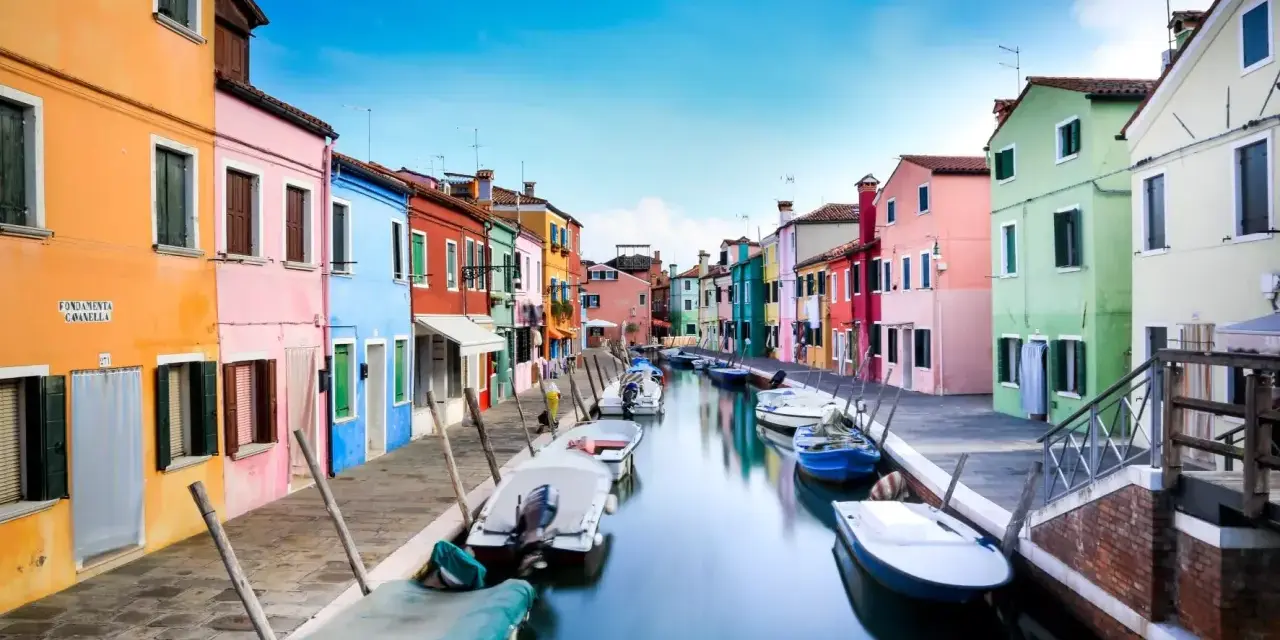 Case colorate lungo un canale a Burano, dove le case sono costruite su palafitte, un'ingegnosa soluzione per capire su cosa è costruita Venezia.