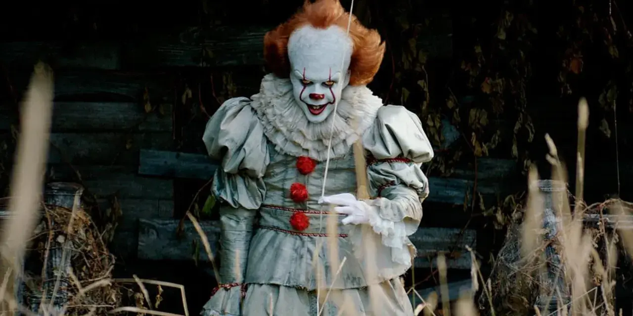 Przerażający klaun Pennywise, znany z horrorów Netflix, wychodzi z mroku.