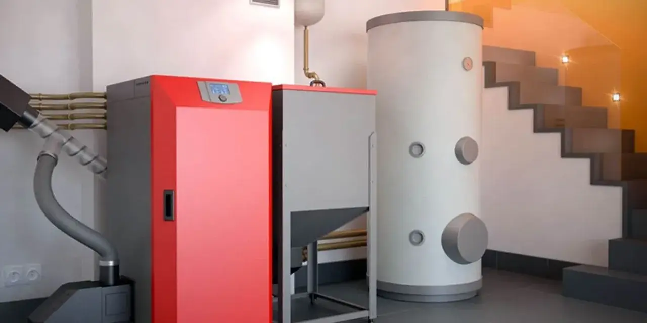 Instalación moderna para cambiar caldera de gas por pellets. Caldera roja, depósito de pellets y acumulador de agua.