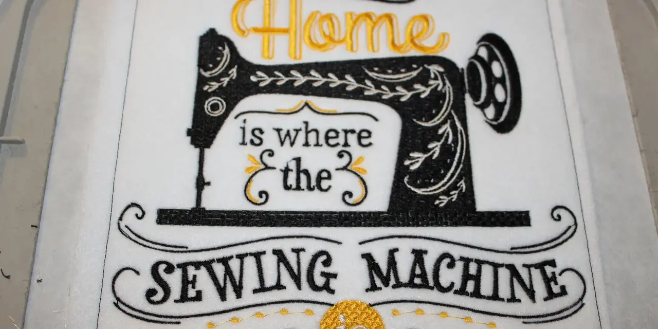 Tipografía para bordar: "Home is where the SEWING MACHINE is". Máquina de coser vintage bordada en negro y dorado.