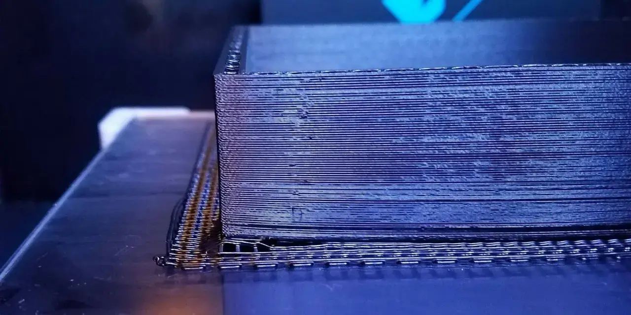 Drukarka 3D tworzy obiekt z czarnego materiału PEEK, warstwa po warstwie.