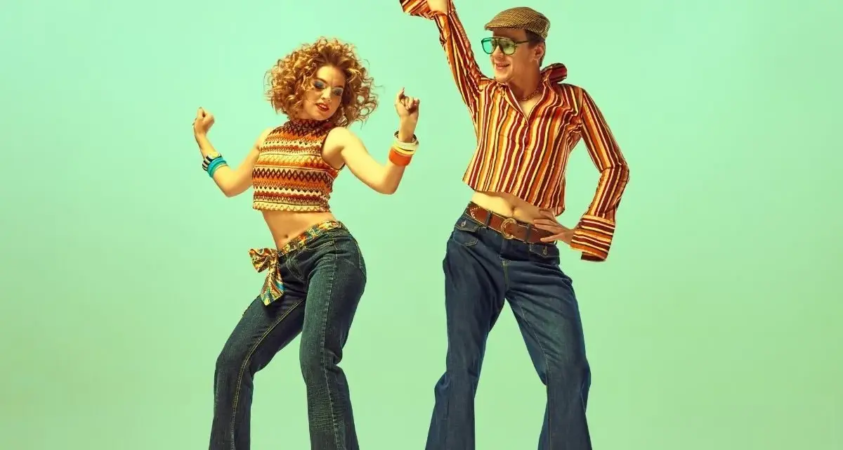 Para tańczy w rytm disco, ubrana w stylowe dzwony i wzorzyste topy, uosabiając modę lat 70.
