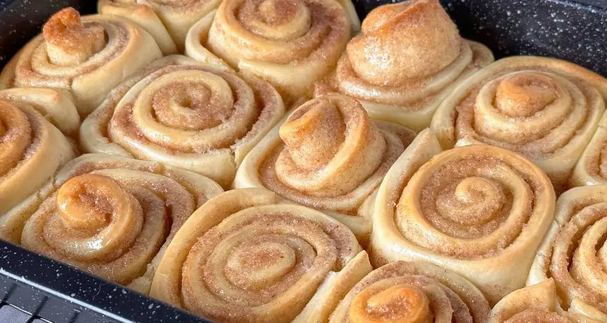 Frisch gebackene Zimtschnecken im Blech, bereit für das Zimtschnecken Rezept. Goldbraun und duftend, ein Genuss!