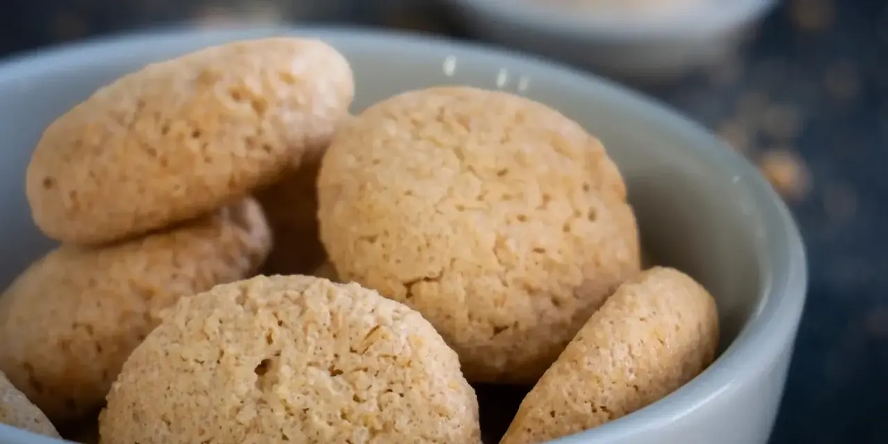 Kleine, goldbraune Amarettini in einer Schale. Dieses Amarettini Rezept ist einfach und gelingt immer.