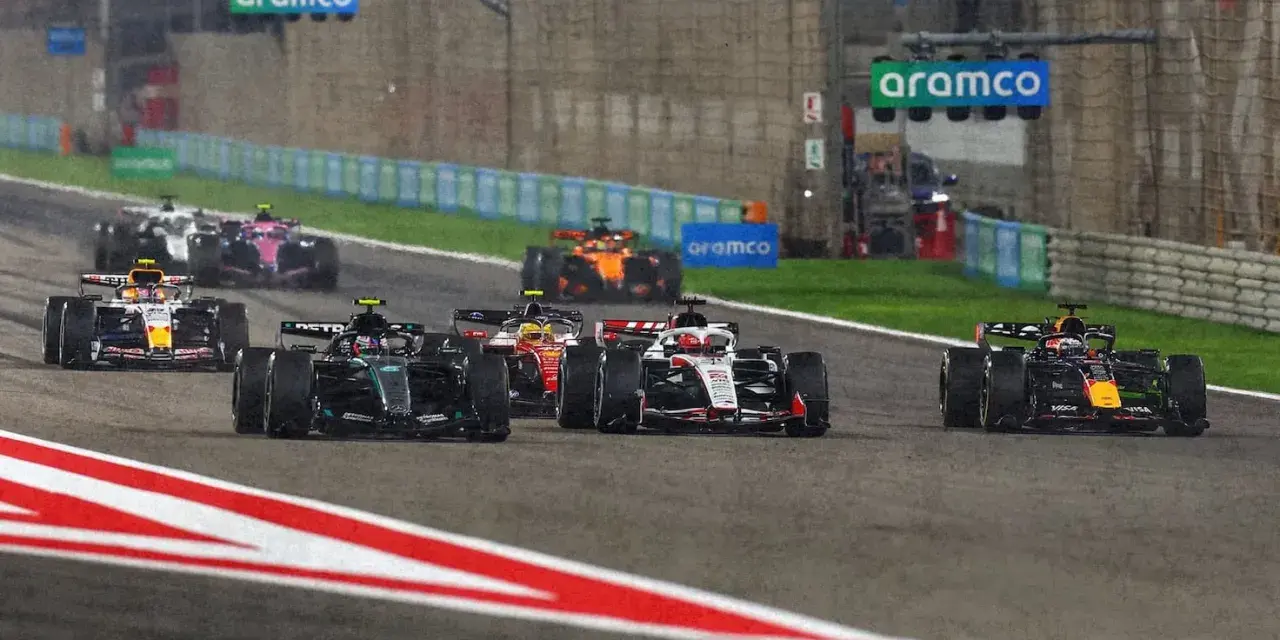 Coches de F1 compiten en una carrera nocturna, anticipando el f1 calendario 2026.