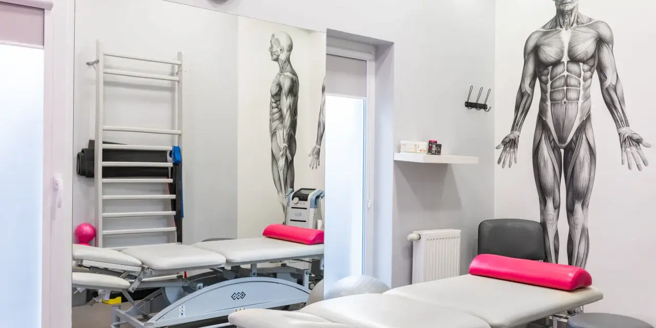 Gabinet rehabilitacyjny z leżankami, drabinką, piłką i aparaturą, w tym magnetronik na kolano.
