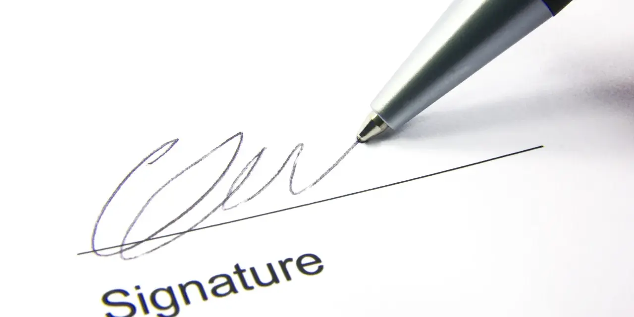 A pen signs a document, finalizing a corporate sponsorship agreement.