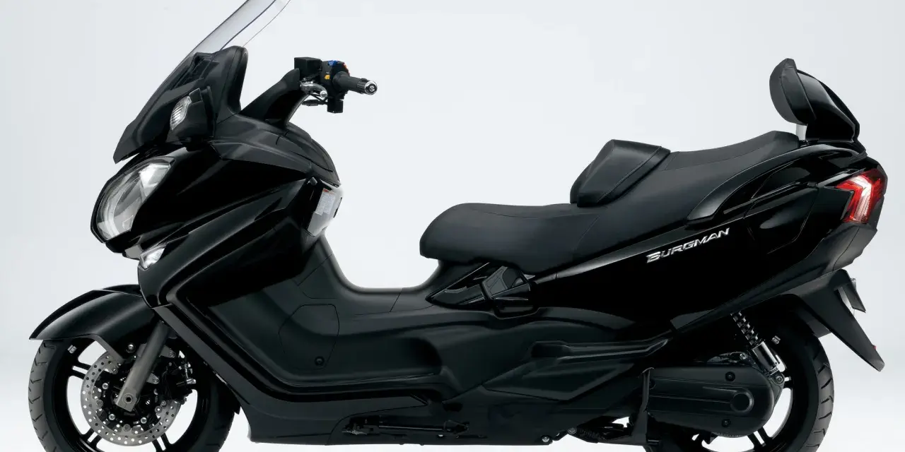 Czarny Suzuki Burgman 650, skuter z wygodnym siedzeniem i dużą szybą. Choć ceniony, ma swoje wady.
