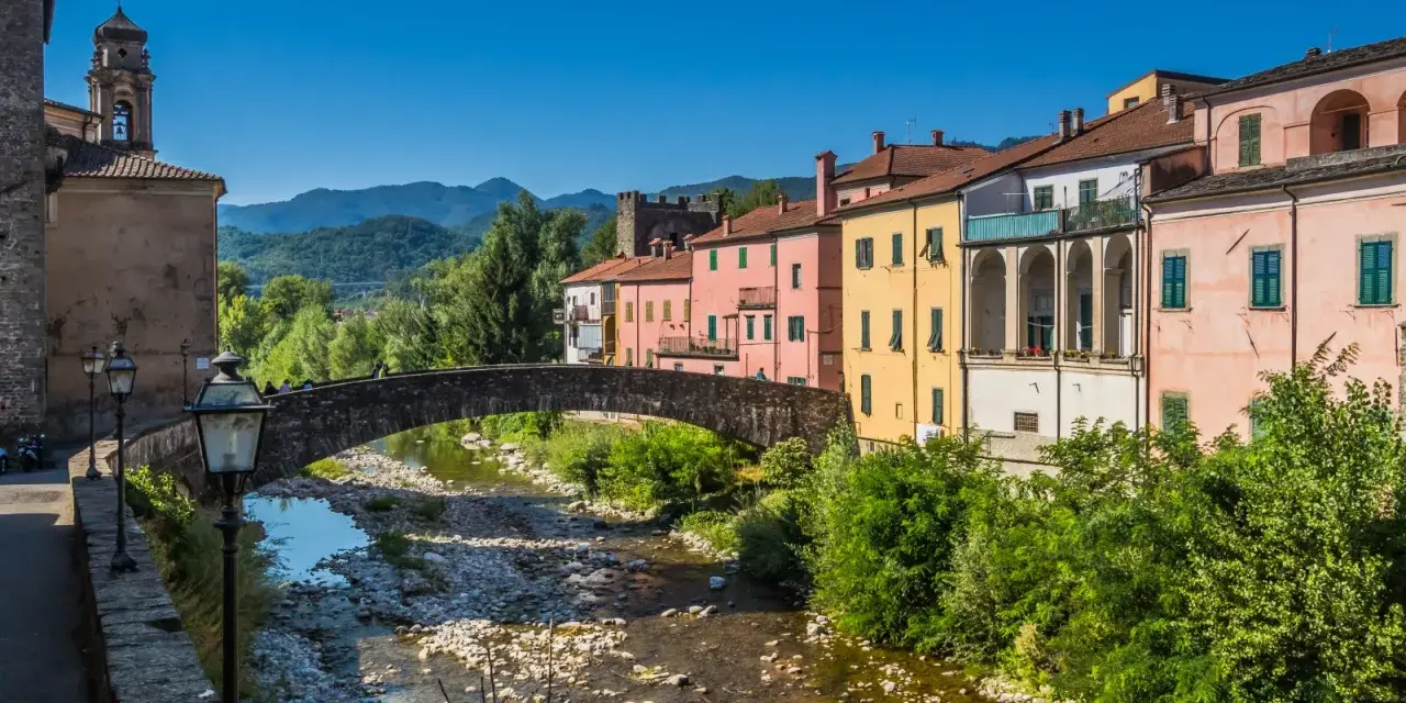 Pontremoli, dove si trova questo pittoresco borgo con case colorate, un ponte ad arco e un fiume.