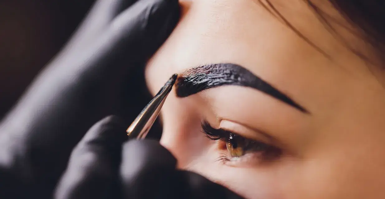 Stylist nakłada hennę pudrową na brwi. Zastanawiasz się, ile kosztuje henna pudrowa?