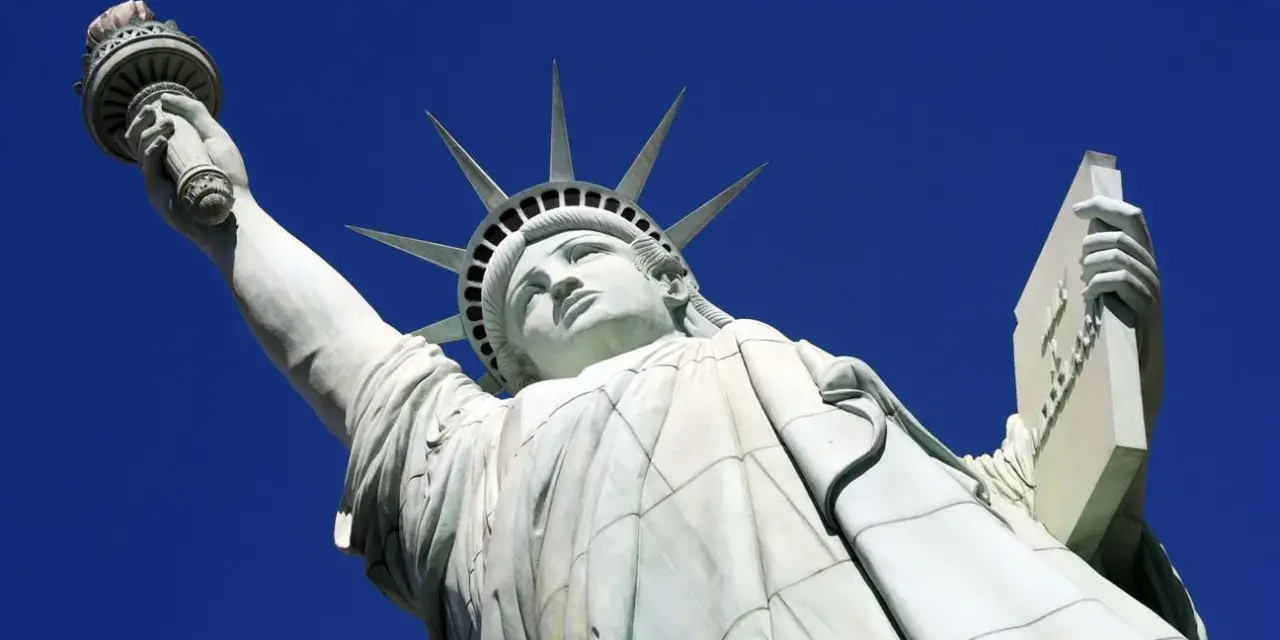 La Statue de la Liberté, une femme emblématique, lève sa torche vers le ciel. Elle porte une tablette, symbole de la loi.
