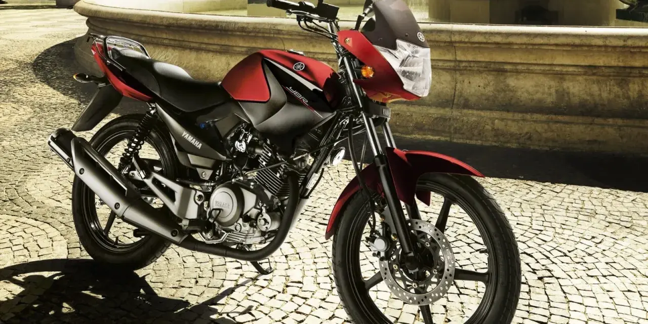 Czerwony motocykl Yamaha YBR 125 na brukowanej ulicy. Sprawdź yamaha ybr 125 dane techniczne, by poznać jego możliwości.