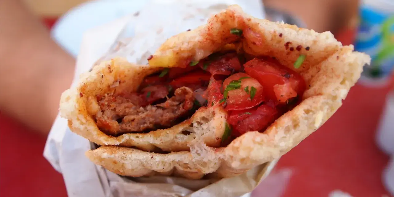 Dürüm kebab z mięsem mielonym, pomidorami i ziołami w bułce.