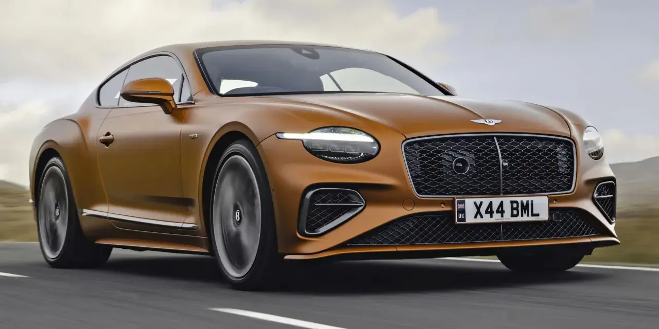 Pomarańczowy Bentley Continental GT na drodze. Sprawdź aktualną bentley cena i poczuj moc.