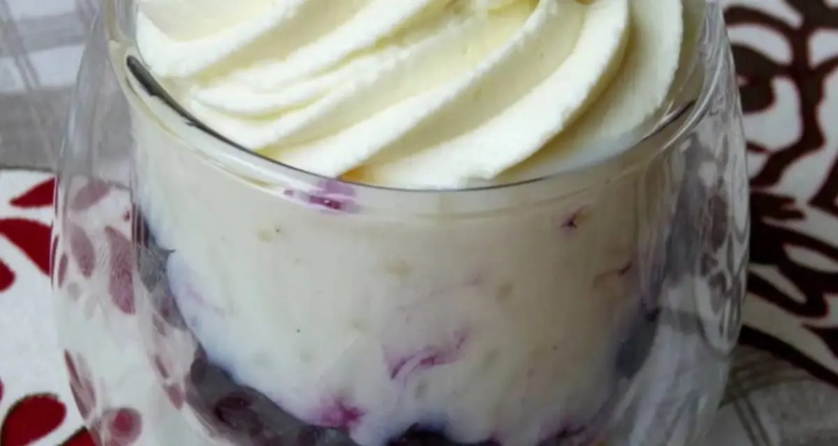 Délicieuse mousse chocolat blanc aérienne, parsemée de fruits rouges, servie dans un verre.