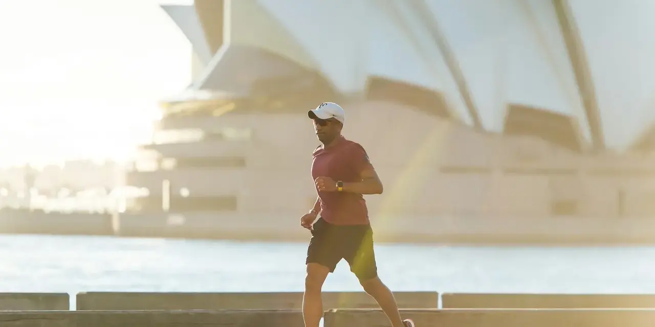 Mężczyzna biegnie przy Operze w Sydney, czerpiąc energię z czystego powietrza. To jego baza tlenowa.