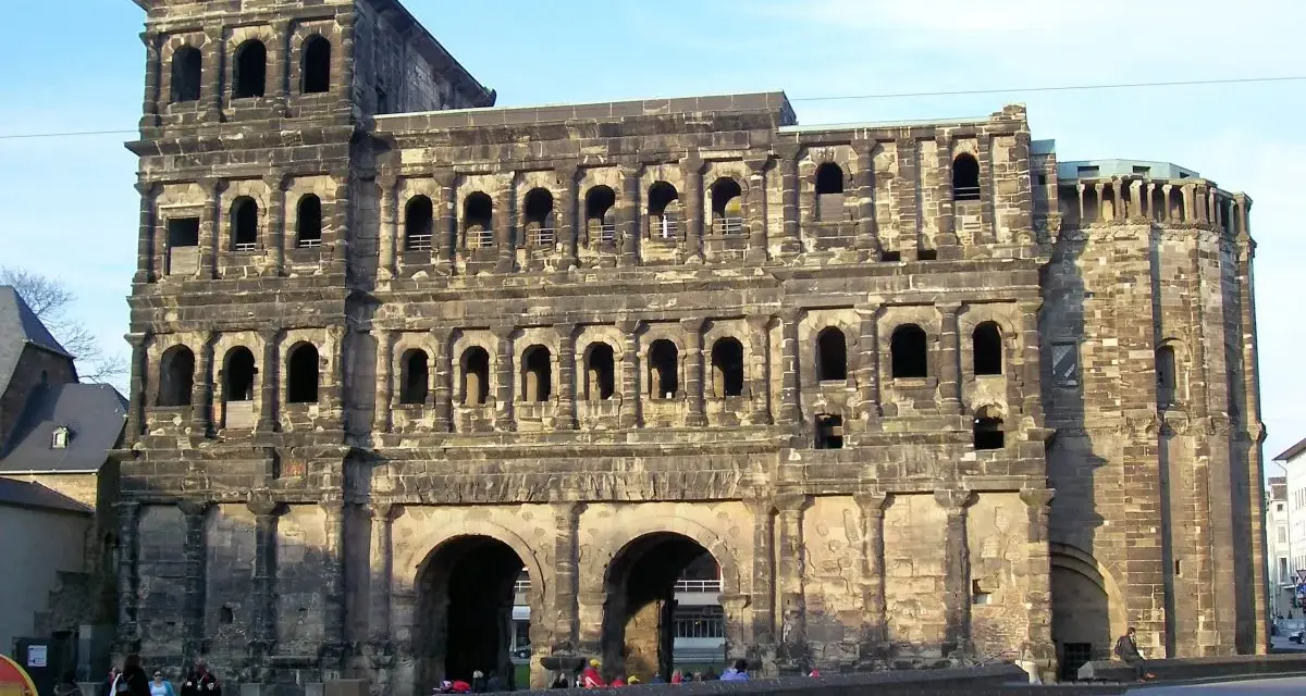 The Porta Nigra, a magnificent example of Trier Roman ruins, stands tall with its imposing stone structure and arched gateways.