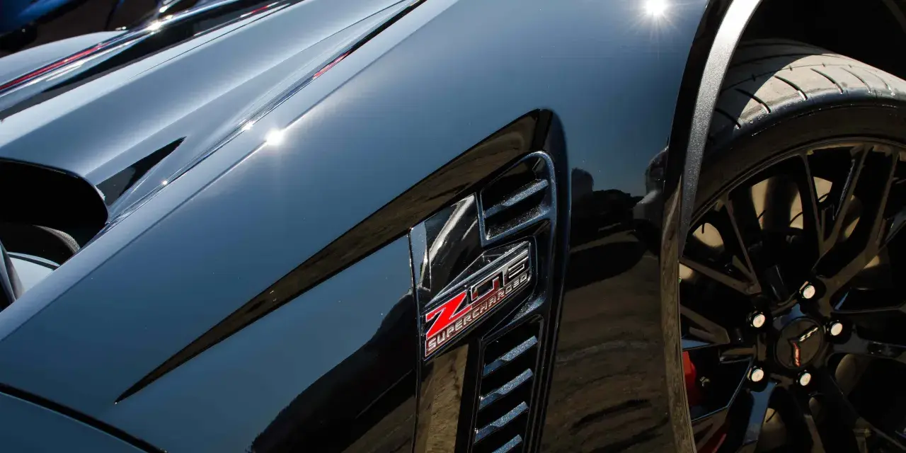 Svart Corvette med "Z06 SUPERCHARGED"-emblem. Lacken är så blank att den nästan ser ut som en keramisk detaljer.