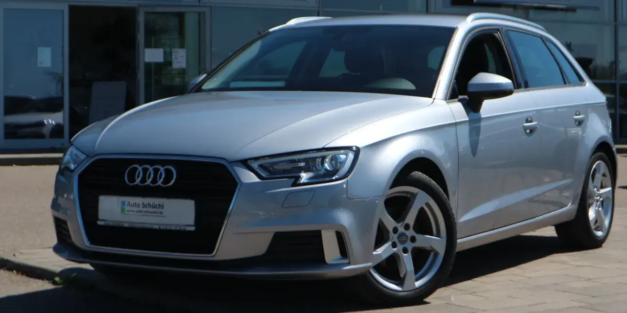 Silberner Audi A3 Avant steht vor einem Autohaus.