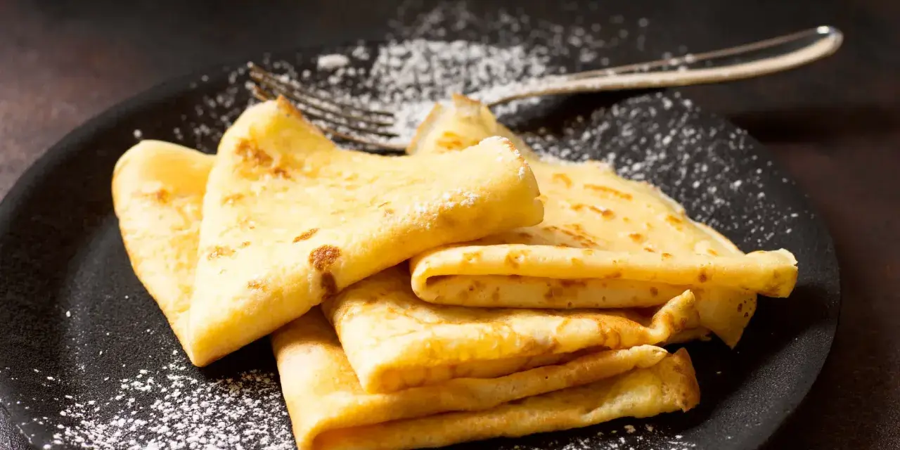 Délicieuses crêpes dorées, saupoudrées de sucre glace, prêtes à être dégustées. La pâte à crêpe Thermomix, un jeu d'enfant !