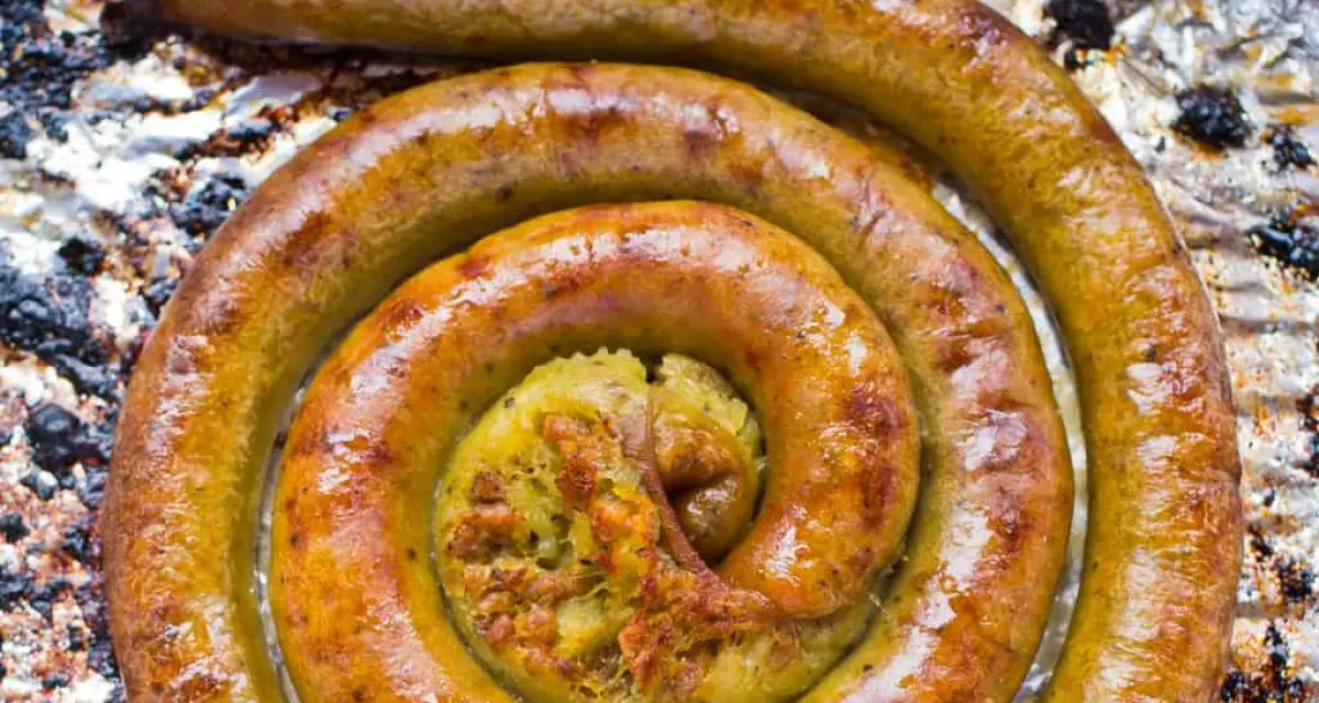 Złocista kiszka ziemniaczana z piekarnika, zawinięta w apetyczny kształt. W środku widać bogate nadzienie.