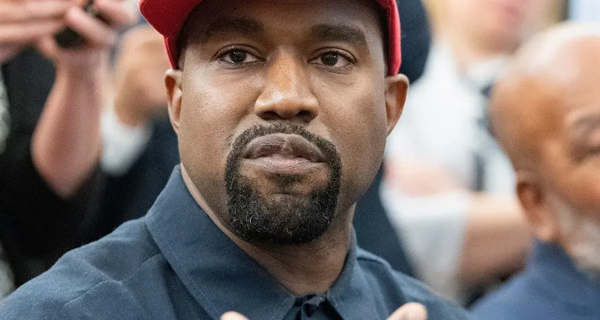 Kanye West w czerwonej czapce i granatowej koszuli, podczas wywiadu.