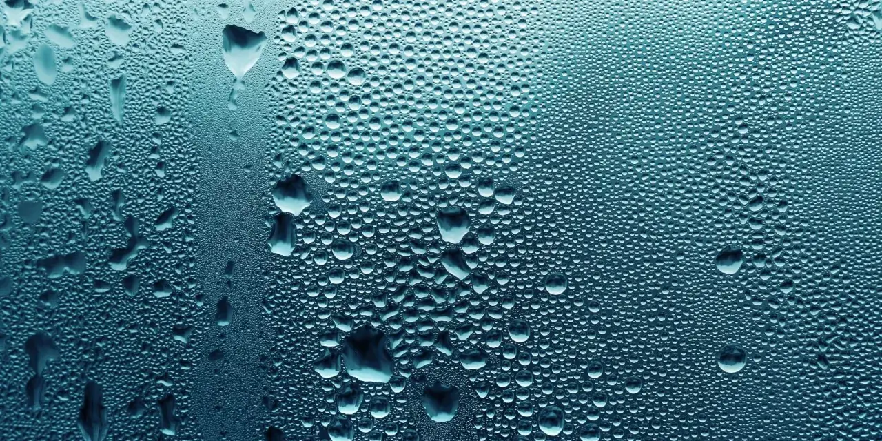 Krople wody na szkle, przypominające małe wywietrzniki w oknach po deszczu.