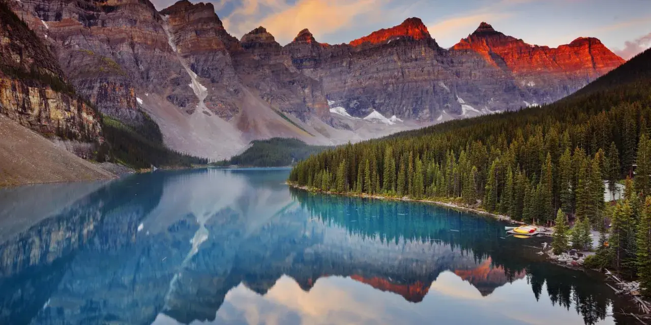 Espectacular reflejo de montañas rocosas y bosque en un lago turquesa. Un ejemplo perfecto de que son los parques naturales, preservando la belleza salvaje.